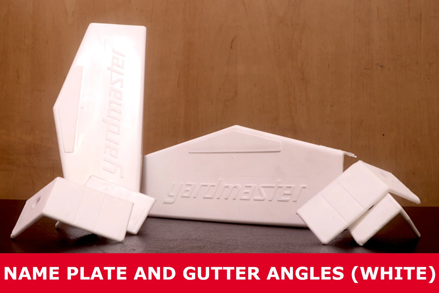 White plastic shed name plate and gutter angles set on a dark surface with wood background